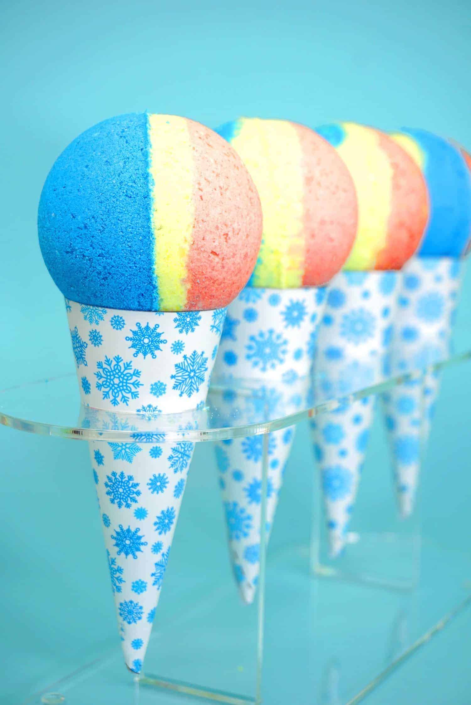 blue, yellow, and pink striped bath bombs in a snowcone