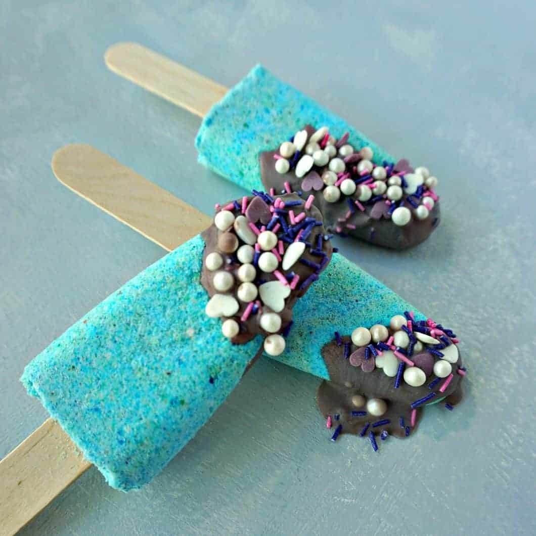 Bath bombs on a lollipop stick that are bright blue, with a chocolate topping appearance with sprinkles