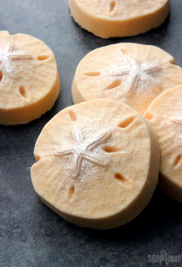 Circular bath bombs in a pale orange colour with a sea star shape on top