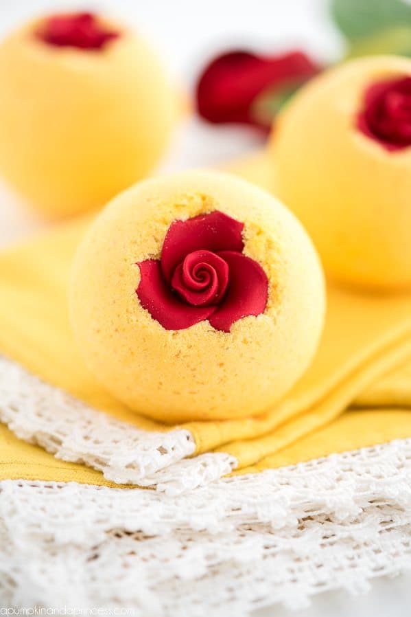 beauty and the beast themed bath bomb that are yellow with a red rose inside