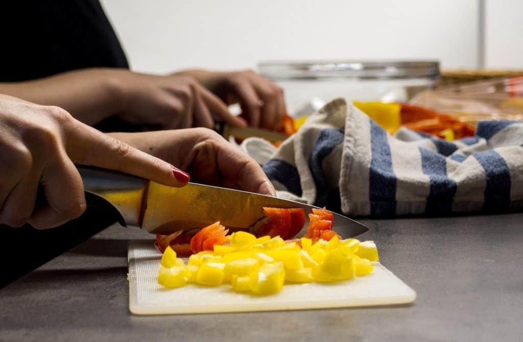 Woman chopping vegetables with knife