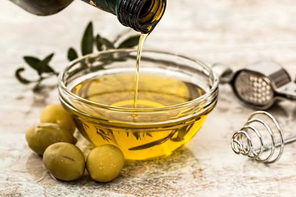 Olive oil being poured into glass dish