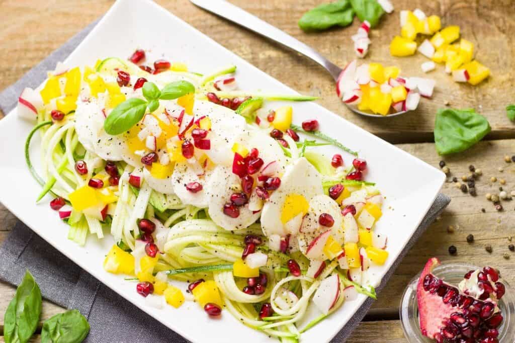 Title image for 8 Easy Low Carb Food Swaps For Healthier Meals - zoodle salad with eggs and pomegranate seeds