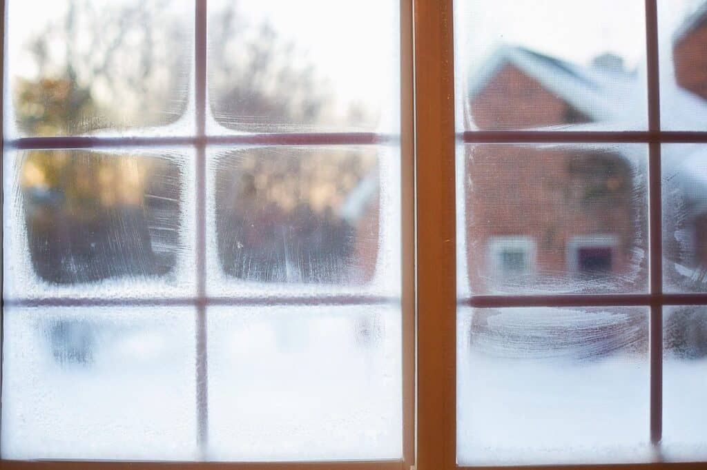 Frosted windows with brown window frames and a snowy outside
