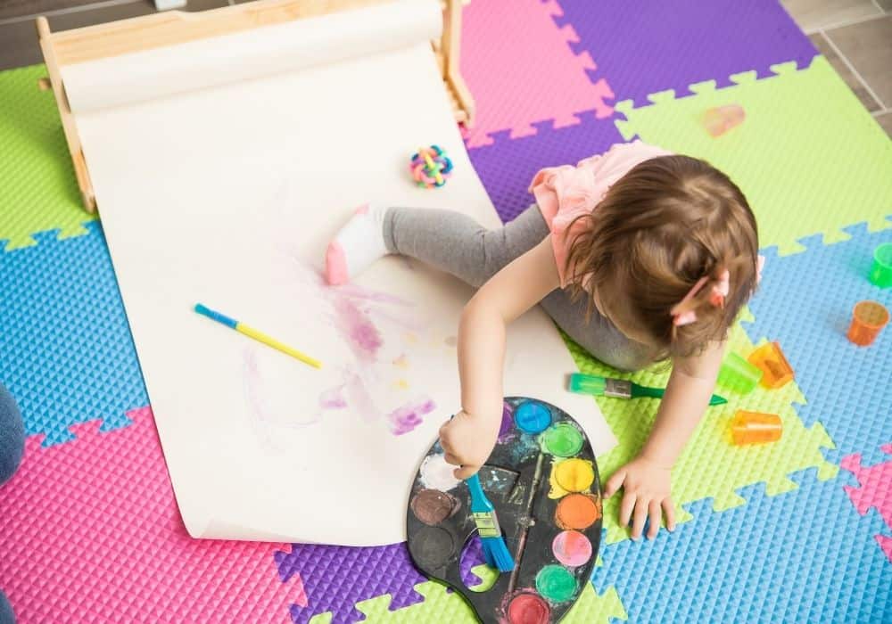 Toddler painting and doing crafts.