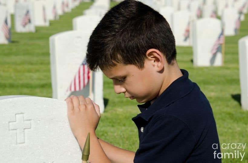 child paying respect at graves of soldiers