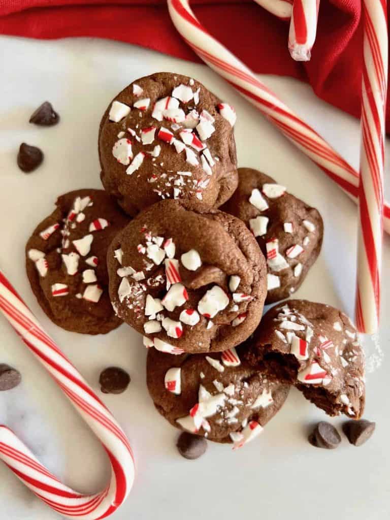 Peppermint Mocha Cookies Lined on a table topped with candy cane pieces and candy canes around them