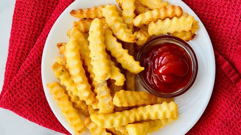 Air Fryer Frozen Crinkle French Fries featured plate full of cooked fries and a small dish of ketchup e1637351333603