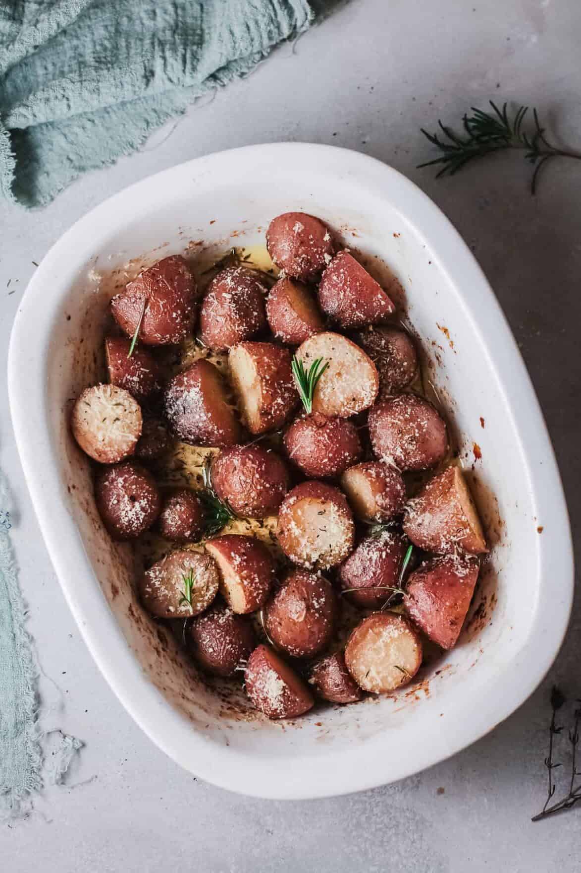 Crispy parmesan herb roasted potatoes in a baking dish, golden and seasoned to perfection.