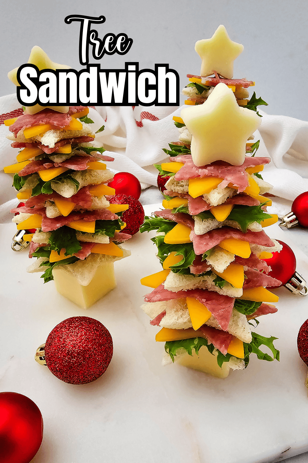 Fun and festive Star Christmas Tree Sandwiches layered with bread, cheese, salami, and lettuce, topped with a star-shaped cheese slice.
